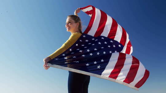 海滩上举着美国国旗的女人