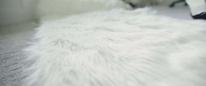 当女人准备测量时，毛茸茸的白色织物卷在奶