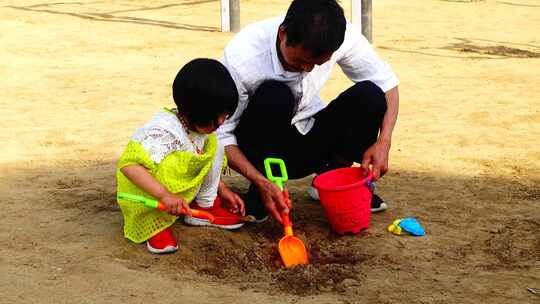 爷爷在带孙女在公园里玩泥巴2