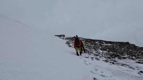 攀登四川岷山山脉主峰雪宝顶的登山者