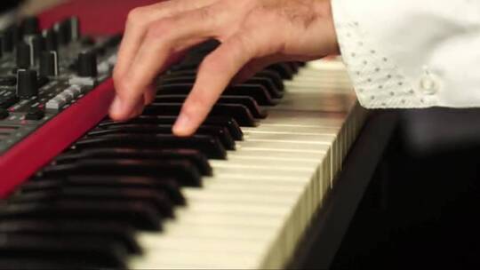 男人弹奏钢琴时手部特写