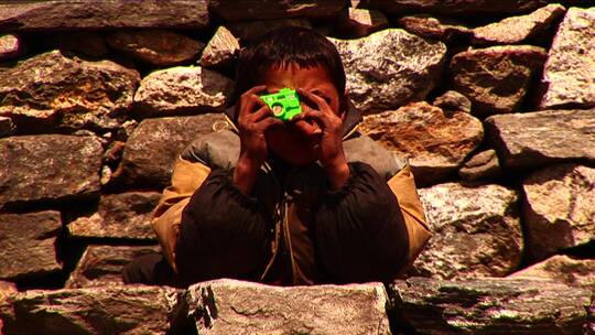 尼泊尔男孩用玩具拍照