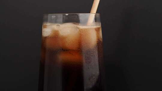 一杯黑色背景上有冰的可乐