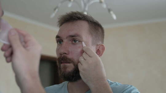 男人在用面部美容小工具视频素材模板下载