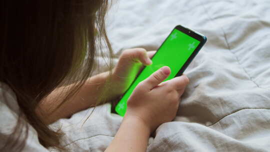 学龄前女孩使用绿屏智能手机
