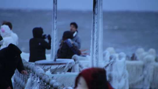 山东威海金海湾栈桥的冰海游客大浪狂风
