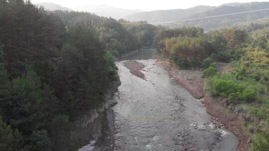 浙江温州泰顺县乌岩岭夕阳下溪流淌过森林