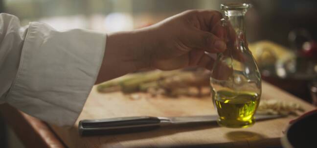 厨师把橄榄油放在桌子上