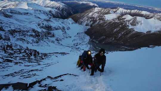 攀登四川岷山山脉主峰雪宝顶的登山者