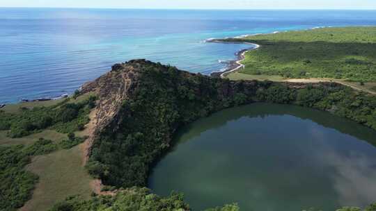 鸟瞰火山口湖，绿色的水被悬崖和绿色植物包