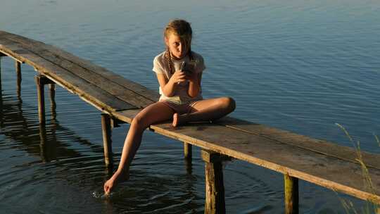 一个女孩在码头玩手机