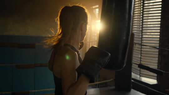 女子拳击手练习出拳在健身房使用包在拳击环