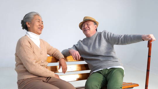 坐在长椅上聊天的老年夫妇