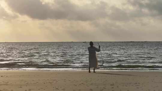 大海沙滩观看日出的女性背影