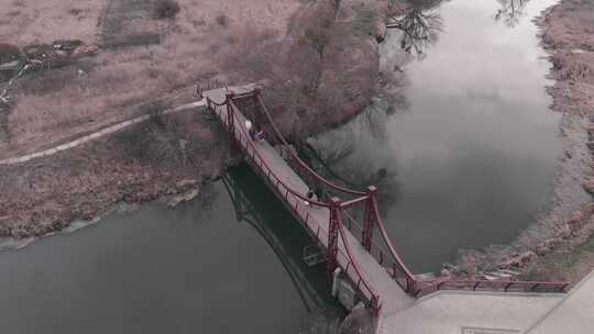 人行桥横跨河流与长廊和公园，空中俯瞰。