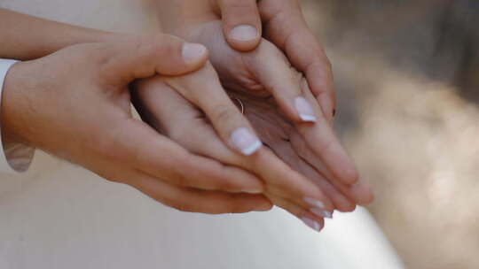 结婚戒指出现在张开的手中。婚纱照会议。