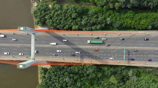 城市汽车在高速公路桥上移动背景光滑的河面无人机视图