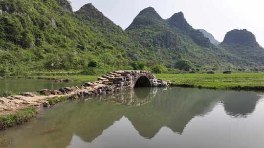 石桥横跨水面周边青山环绕的美景