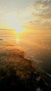 日出照亮热带岛屿上的薄雾黎明破晓海上鸟瞰