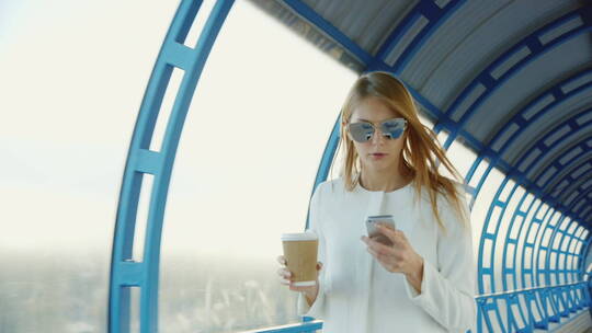 边喝咖啡边用手走在隧道上的女人视频素材模板下载