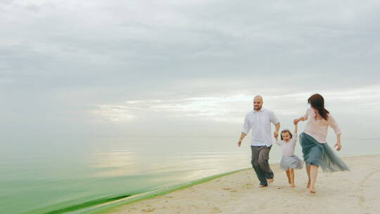 在沙滩上奔跑的一家人