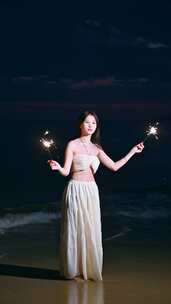 海南三亚一位亚洲美女在沙滩上点燃烟花