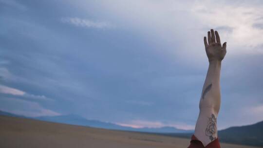 一名女子在沙漠中做瑜伽时伸展身体视频素材模板下载