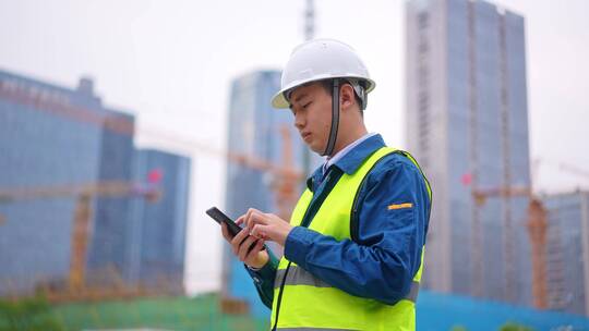 年轻工程项目经理施工现场使用手机指挥施工