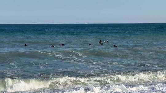 一群冲浪者在海上等待波浪