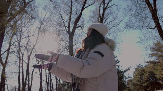 快乐的青年女人在雪地里玩耍