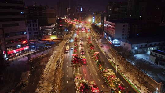 消防队消防车行驶在城市夜景街道上的航拍