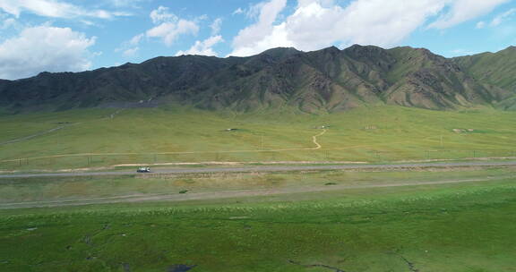 新疆广袤草原上汽车在公路上行驶