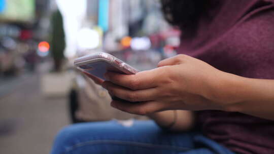 一位年轻的拉丁裔女性在她的手机上输入一条消息慢动作