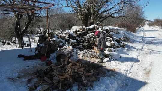 在雪地上清理木头的男人视频素材模板下载