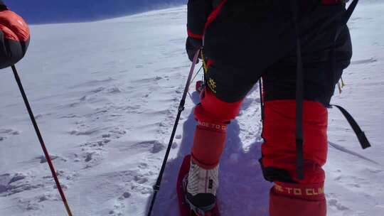 风雪中攀登慕士塔格雪山的登山者