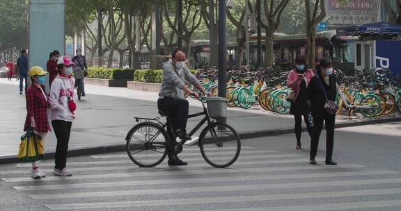 疫情下的成都街头行人戴口罩过马路