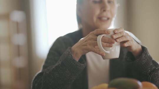 女人拿着杯子说话