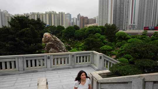 背景为南莲花园露台爬楼梯的女人和香港城市