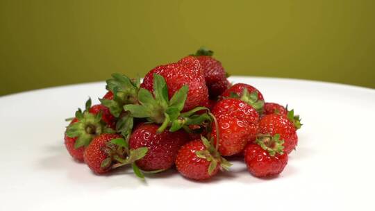 在白色背景上孤立的有机红裂纹草莓浆果堆