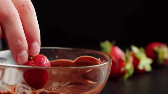 用草莓蘸巧克力酱的画面特写