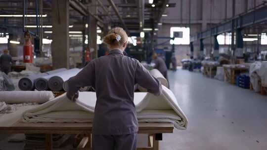 工厂女工整理纺织布料