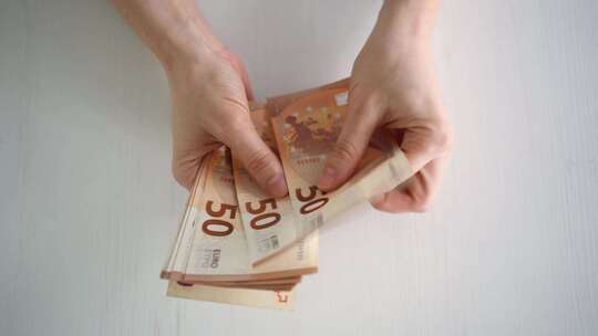 计算欧元钞票时女性的手部特写欧洲经济的价值