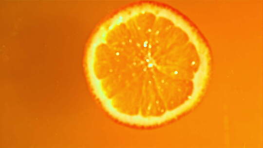 新鲜橙子碎片落入橙汁中溅起水花