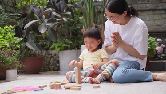 小朋友和妈妈在院子里一起玩耍做游戏