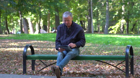 中年男人坐在公园长椅上