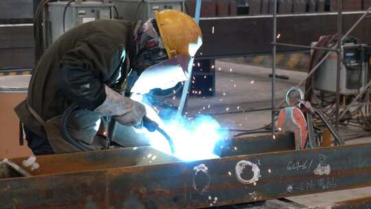 工厂的电焊工焊接钢材升格