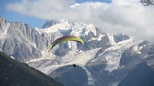雪山群中飞翔的滑翔伞视频素材模板下载
