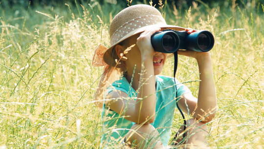 女孩通过双筒望远镜观看野生动物视频素材模板下载