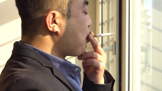 商务中年成功男人窗前抽烟背影