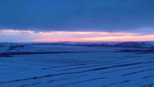 航拍浓郁夕阳下的垦区雪原